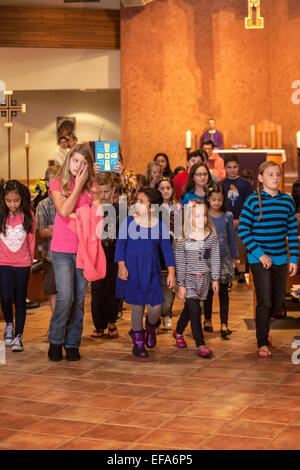 E multirazziale i figli piccoli noti come Tiny Tim marzo giù il corridoio a San Timoteo della Chiesa Cattolica, Laguna Niguel, CA. Nota vangelo essendo eseguito in background. Foto Stock