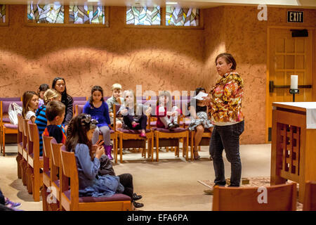 E multirazziale i figli piccoli noti come Tiny Tim assistere ad una lezione religiosa nella cappella di San Timoteo della Chiesa Cattolica, Laguna Niguel, CA. Nota insegnante. Foto Stock