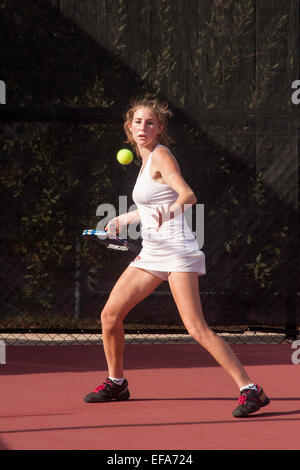 Con accurata fasatura, un giovane giocatore di tennis si prepara a tornare a servire in San Juan Capistrano, CA. Foto Stock