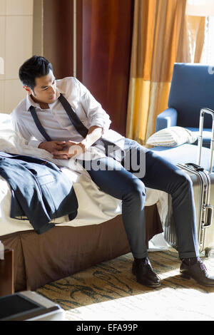 Giovane imprenditore di riposo in camera di albergo Foto Stock