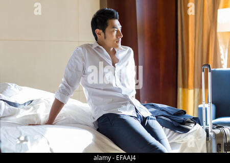 Giovane imprenditore di riposo in camera di albergo Foto Stock