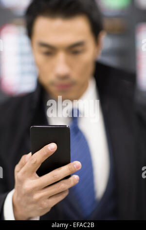 Giovane imprenditore utilizzando smart phone in aeroporto Foto Stock