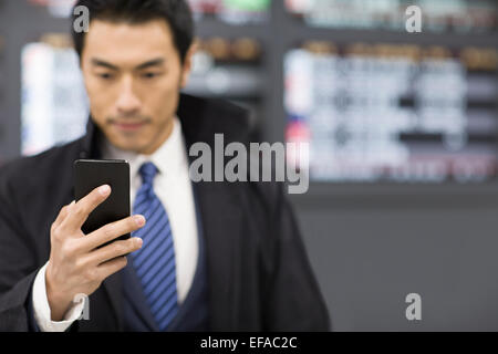 Giovane imprenditore utilizzando smart phone in aeroporto Foto Stock