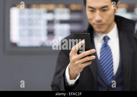 Giovane imprenditore utilizzando smart phone in aeroporto Foto Stock