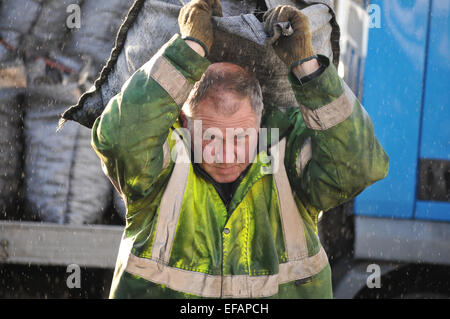 L'uomo offrendo i sacchi di carbone sotto la pioggia. Cornovaglia, England, Regno Unito Foto Stock