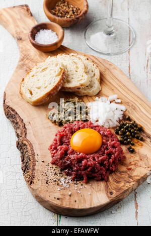 Tartare di manzo con capperi e cipolla fresca di olive wood board con il vino Foto Stock