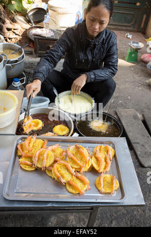 Rendendo Bahn Tom o frittelle di gamberetti nelle strade di Hanoi Foto Stock