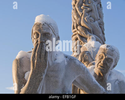 Inverno in Vigelandsparken, Oslo Norvegia, neve dà le sculture una speciale finitura, granito vecchia coppia nella luce del sole dorato Foto Stock