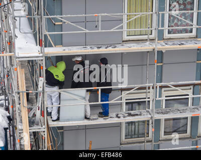 I lavoratori sui ponteggi, ristrutturando un vecchio edificio per uffici con nuovi elementi di facciata Oslo Norvegia Foto Stock