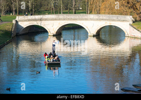 Cambridge, Regno Unito. Il 30 gennaio, 2015. Meteo REGNO UNITO: turisti godere punting sul fiume Cam, Cambridge in inverno il sole, in un pomeriggio freddo con un bitingly freddo vento del nord. L'est dell'Inghilterra ha in gran parte sfuggiti alla neve che ha colpito le Midlands e le parti settentrionali del paese. Sterline continuare a esercitare la loro attività lungo il "spalle" degli edifici storici della Cambridge University. Credito: Julian Eales/Alamy Live News Foto Stock