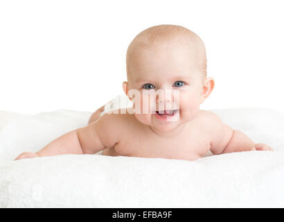 Carino sorridente bambino giacente su asciugamano bianco Foto Stock