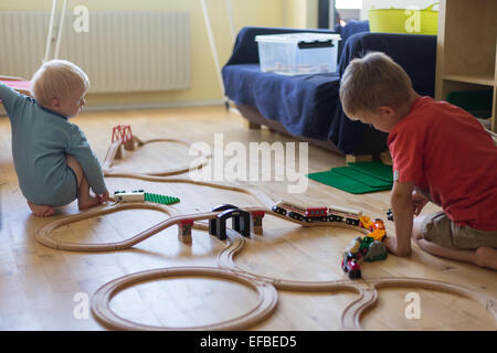 Due ragazzi giocare con un legno treno brio Foto Stock
