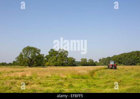 Il trattore e il fieno falciatrice campo di falciatura, Oxfordshire, Inghilterra Foto Stock