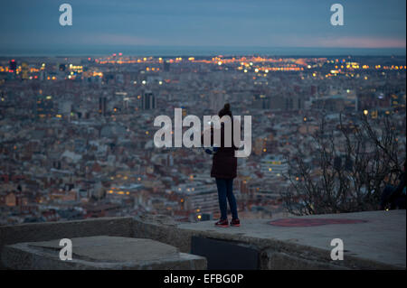 Barcellona, Spagna. Il 30 gennaio, 2015. Una ragazza prende una foto con il telefono presso la città di Barcellona dalla cima di un vecchio bunker antiaerea. In cima al Carmelo quartiere di Barcellona sono alcuni vecchi air raid bunker dal tempo della guerra civile spagnola da cui tutta la città può essere visto. Credito: Jordi Boixareu/Alamy Live News Foto Stock