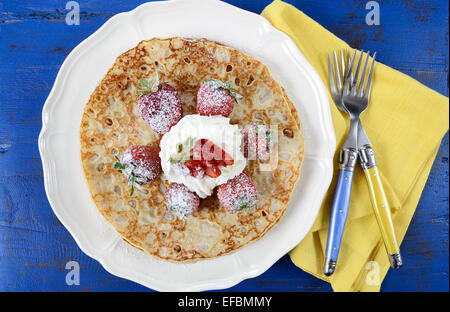 Martedì grasso Martedì Pancake pancake con fragole e panna on dark blue vintage shabby chic tavolo. Foto Stock