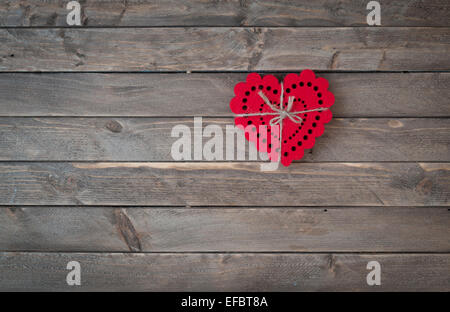 Forme di cuore legati insieme su un sfondo di legno. Foto Stock