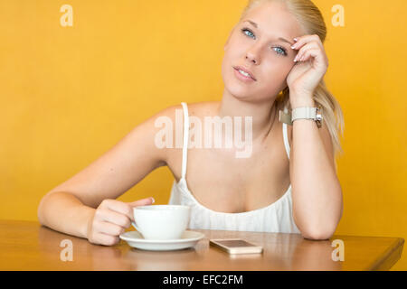 Sorridente giovane donna bere il caffè al caffè Foto Stock