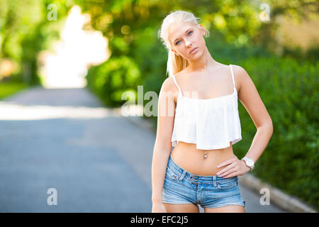 Carino teen ragazza con parte superiore sorge in strada Foto Stock