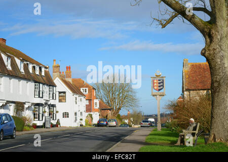 Uomo anziano seduto sul sedile del villaggio in Winchelsea, East Sussex, England, Regno Unito Foto Stock