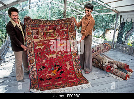 Due rappresentanti del Kashmir orgogliosamente mostrare tradizionali tessuti a mano tappeti orientali per i visitatori a dal lago a Srinagar in India-governata regione del Kashmir. Foto Stock