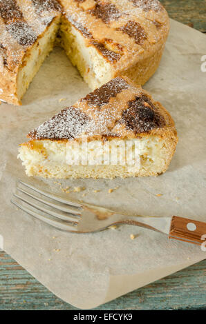 Pezzo di napoletano torta di Pasqua su carta di avvolgimento. Accanto il coltello e forchetta. Stile rustico. Messa a fuoco selettiva Foto Stock