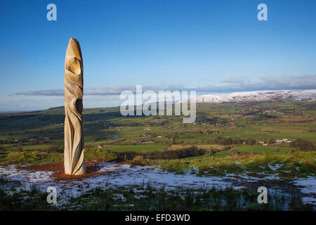 Scultura su Jeffreys Hill vicino Longridge in Lancashire, Preston, Regno Unito gennaio tempo invernale. Halima Cassell's Sun Catcher scolpito in legno Landmark scultura statua che guarda attraverso vale di Chipping e le campane della Foresta di Bowland. Il tronco di un albero di quercia di 150 anni è stato utilizzato in una serie di quattro commissioni temporanee, artisti per lavori ambiziosi nel paesaggio che rispondono ad alcune delle località più amate intorno alla foresta di Bowland. Le commissioni fanno parte di Bowland rivelato, celebrando cinquanta anni della Foresta di Bowland come un'area di eccezionale bellezza naturale. Foto Stock