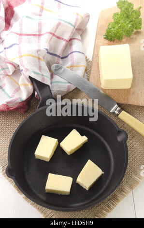 Il burro freddo cubetti in una ghisa pan Foto Stock