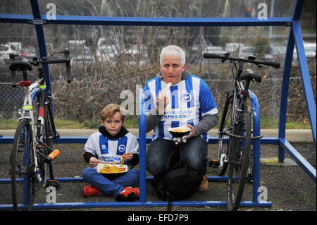 Brighton e Hove Albion tifosi di calcio giovani e anziani mangiare Pesce e patatine prima di una partita - solo per uso editoriale Foto Stock