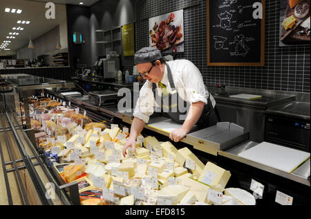 Giovane uomo che lavora sul contatore di formaggio in un supermercato Waitrose REGNO UNITO Foto Stock