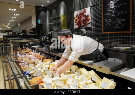 Giovane uomo che lavora sul contatore di formaggio in un supermercato Waitrose REGNO UNITO Foto Stock