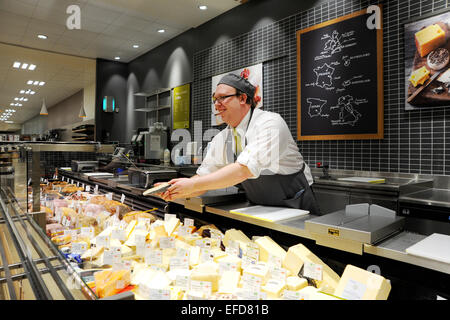 Giovane uomo che lavora sul contatore di formaggio in un supermercato Waitrose REGNO UNITO Foto Stock