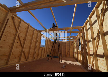 La striscia di Gaza. Il 1° febbraio 2015. Un lavoratore palestinese lavora sulla costruzione di una nuova casa di legno nel sud della striscia di Gaza city di Khan Yonis, il 1 febbraio, 2015. In un tentativo di ricostruire la guerra-case strappati nella Striscia di Gaza sotto le circostanze della mancanza di materiali di costruzione, palestinesi residenti ha iniziato a costruire case di legno. Secondo gli appaltatori locali, la striscia di Gaza ha bisogno di circa 2 milioni di tonnellate di cementi e 5 milioni di tonnellate di greggio di altri materiali da costruzione per ricostruire ciò che era stato distrutto da Israele durante l'ultimo conflitto. © Khaled Omar/Xinhua/Alamy Live News Foto Stock