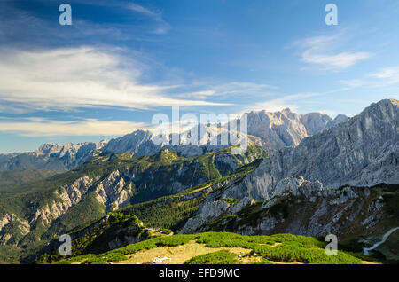 Antenna vista del paesaggio delle Alpi in estate la luce del sole di alta montagna con picchi di valle verde e profondo cielo blu Foto Stock