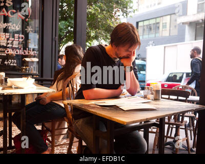 Hong Kong 2015 - Uomo leggendo il giornale in un cafe Foto Stock