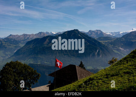 Vista delle Alpi Svizzere dal Pilatus montagna con una bandiera svizzera in primo piano Foto Stock