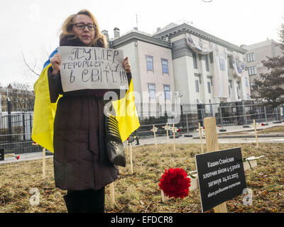 1 febbraio 2015 - croci poste dagli attivisti e recanti i nomi di 30 persone che sono morte nel bombardamento in Mariupol su Jan, 24 sono visti in primo piano come donna in piedi con un banner ''Putler - â"-1 attentati nel mondo'' vicino all'Ambasciata russa a Kiev, Ucraina, Domenica, 1 febbraio 2015. Credito: Igor Golovniov/ZUMA filo/Alamy Live News Foto Stock