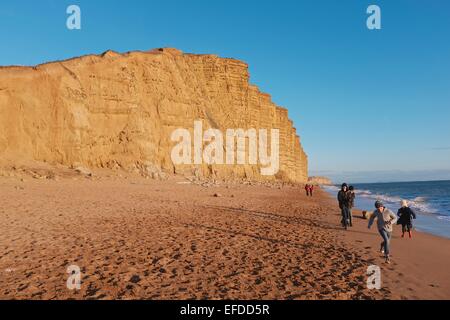 West Bay, Dorset, Regno Unito.Il 1 febbraio 2015. Domenica passeggini a piedi sotto le scogliere dorate reso famoso nella fiction TV Broadchurch. Poiché la seconda serie di dramma popolare ha mandato in onda vi è stata triplice aumento delle ricerche online per la proprietà nella zona. Credito: Tom Corban/Alamy Live News Foto Stock