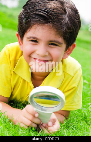 1 bambino indiano boy park lente di ingrandimento ricerca Foto Stock