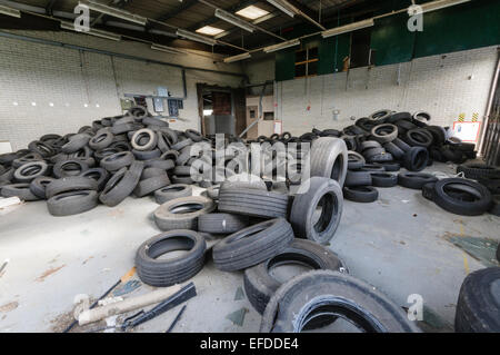 Pneumatici illegalmente oggetto di dumping in una fabbrica abbandonata. Foto Stock