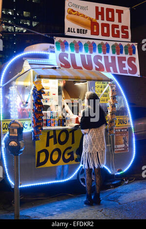 Un hot dog distributore vende a una donna dalla loro elegante illuminate al neon rimorchio su Lower Broadway a Nashville, TN, Music City USA Foto Stock