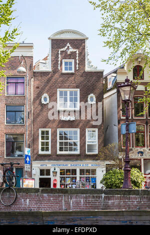 Facciata del XVII secolo a capanna tradizionale architettura olandese di fianco al canale town house su un piano terra shop in Amsterdam, costruito nel 1687 Foto Stock