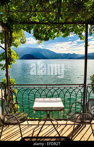 Vista di un piccolo tavolo sotto un pergolato con vista lago, Varenna, Lago di Como, Lombardia, Italia Foto Stock