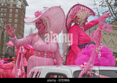 Due frilly costume ladies tutti in rosa con pelle di colore rosa, uno con la barba, ride e wave alle persone durante il Mardi Gras Parade Foto Stock