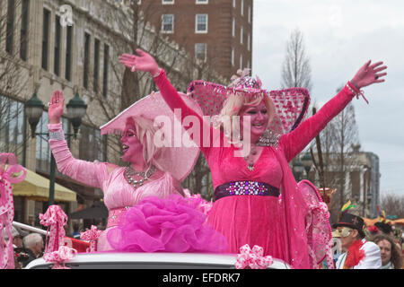 Due frilly costume ladies tutti in rosa con pelle di colore rosa, uno con la barba, ride e wave alle persone durante il Mardi Gras Parade Foto Stock