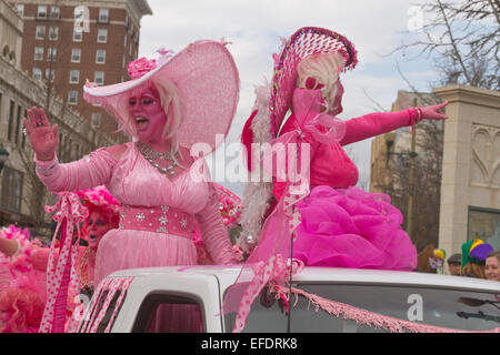 Due frilly costume ladies tutti in rosa con pelle di colore rosa, uno con la barba, ride e wave alle persone durante il Mardi Gras Parade Foto Stock