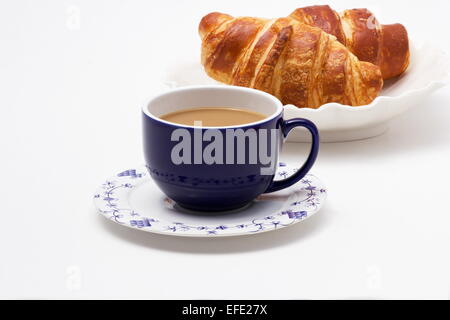 Una tazza di caffè e croissant su sfondo bianco Foto Stock