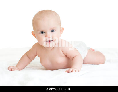 Carino sorridente bambino giacente su asciugamano bianco nel pannolino Foto Stock