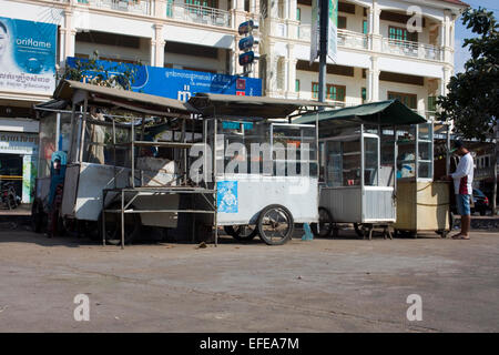 Un uomo sta preparando mobile carrelli di cibo per la vendita di cibo di strada su una strada di città in Kampong Cham, Cambogia. Foto Stock