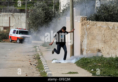 Nablus, West Bank città di Nablus. 2° febbraio 2015. Un manifestante palestinese calci indietro una lacrima-bombola del gas sparato dai soldati israeliani durante scontri nei pressi di insediamento ebraico di Majdolim, vicino al villaggio di Qusra, sud della Cisgiordania città di Nablus, nel febbraio 2, 2015. Testimoni ha detto che gli abitanti di un villaggio palestinese ha chiuso la strada principale per la liquidazione dopo i militari israeliani hanno distrutto due camere agricole e un pozzo di mancare di permessi di costruzione. © Nidal Eshtayeh/Xinhua/Alamy Live News Foto Stock