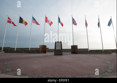 Bandiere di volare a Juno Beach, Normandia, un memoriale per i soldati caduti a Saint-Aubin sur mer Foto Stock